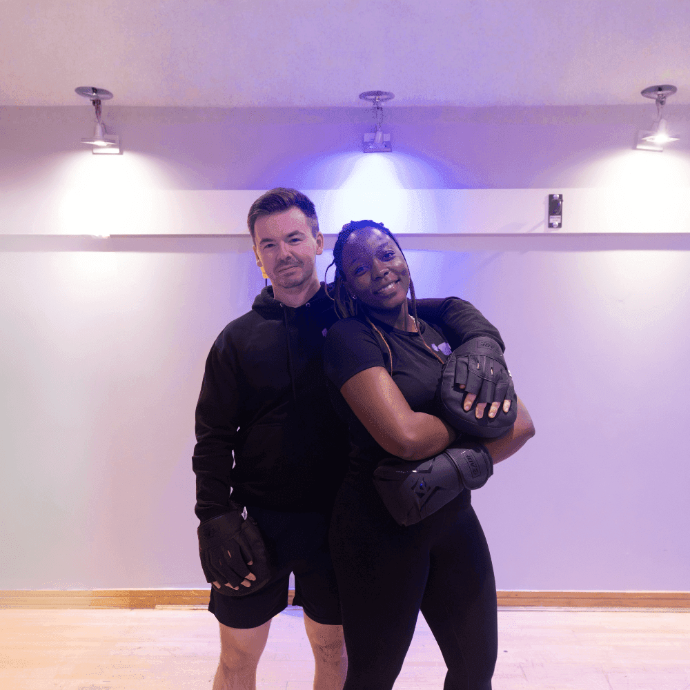 Two people wearing training gloves in a fitness studio