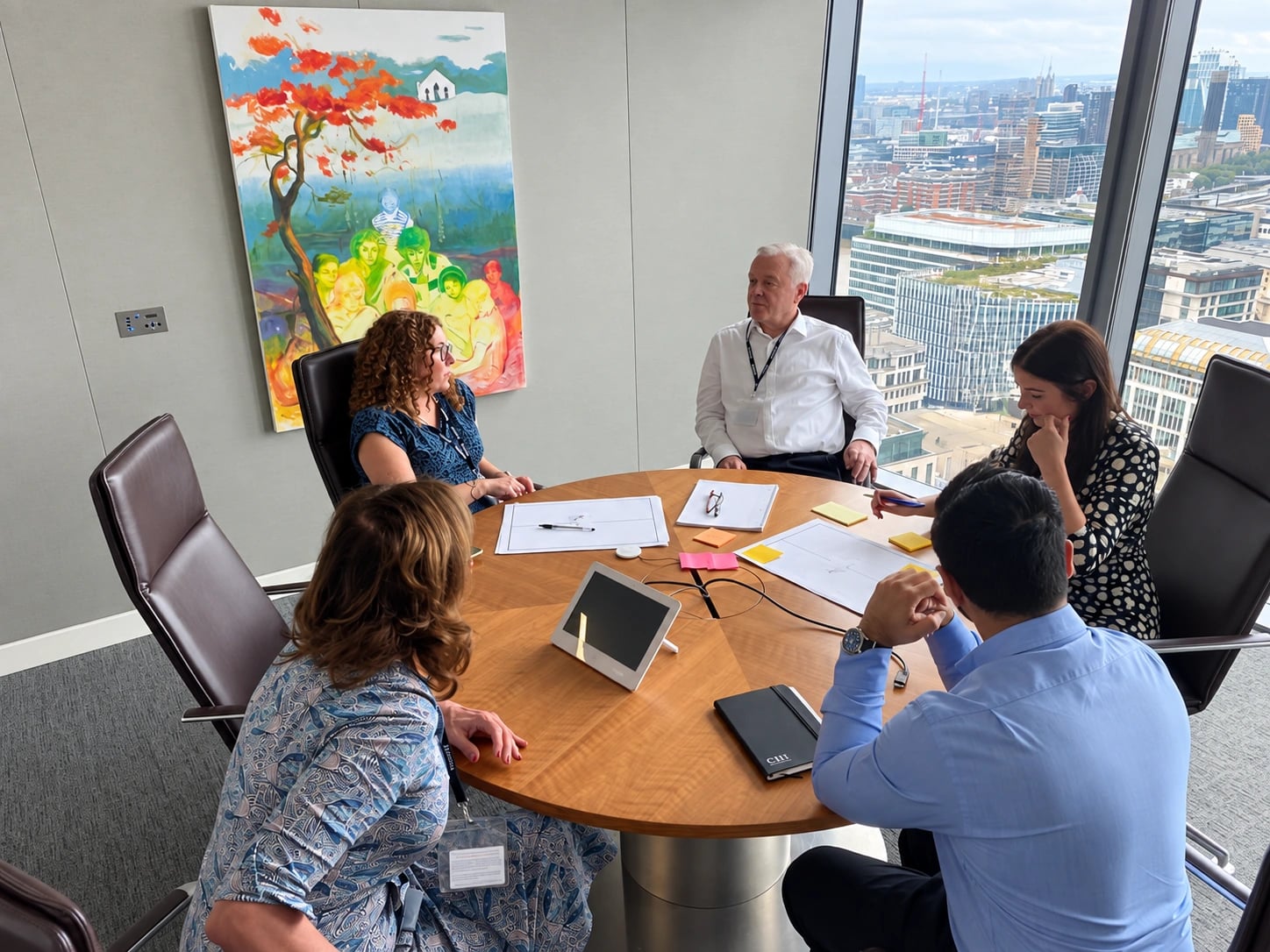 Five people discussing ideas around a table during an INSO session with CISI.